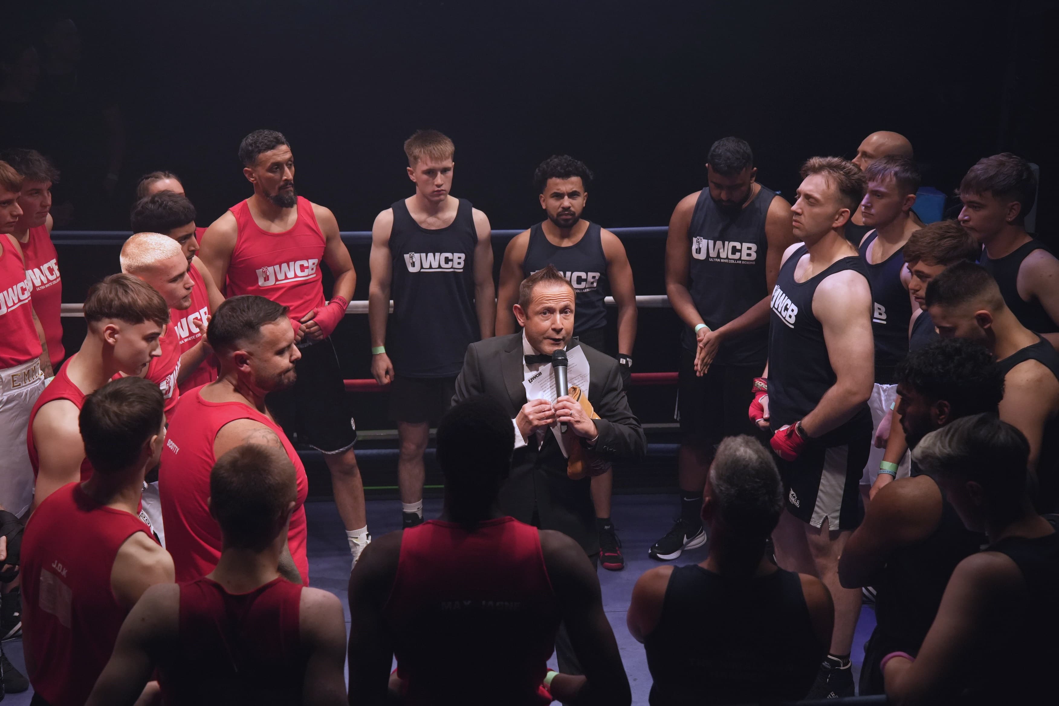 Nick Mummery in the ring surrounded by fighters