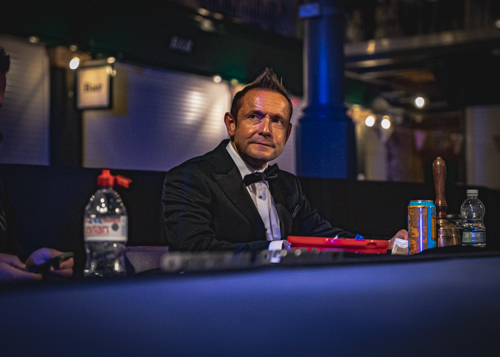 Nick Mummery seated ringside in formalwear before a fight-night event